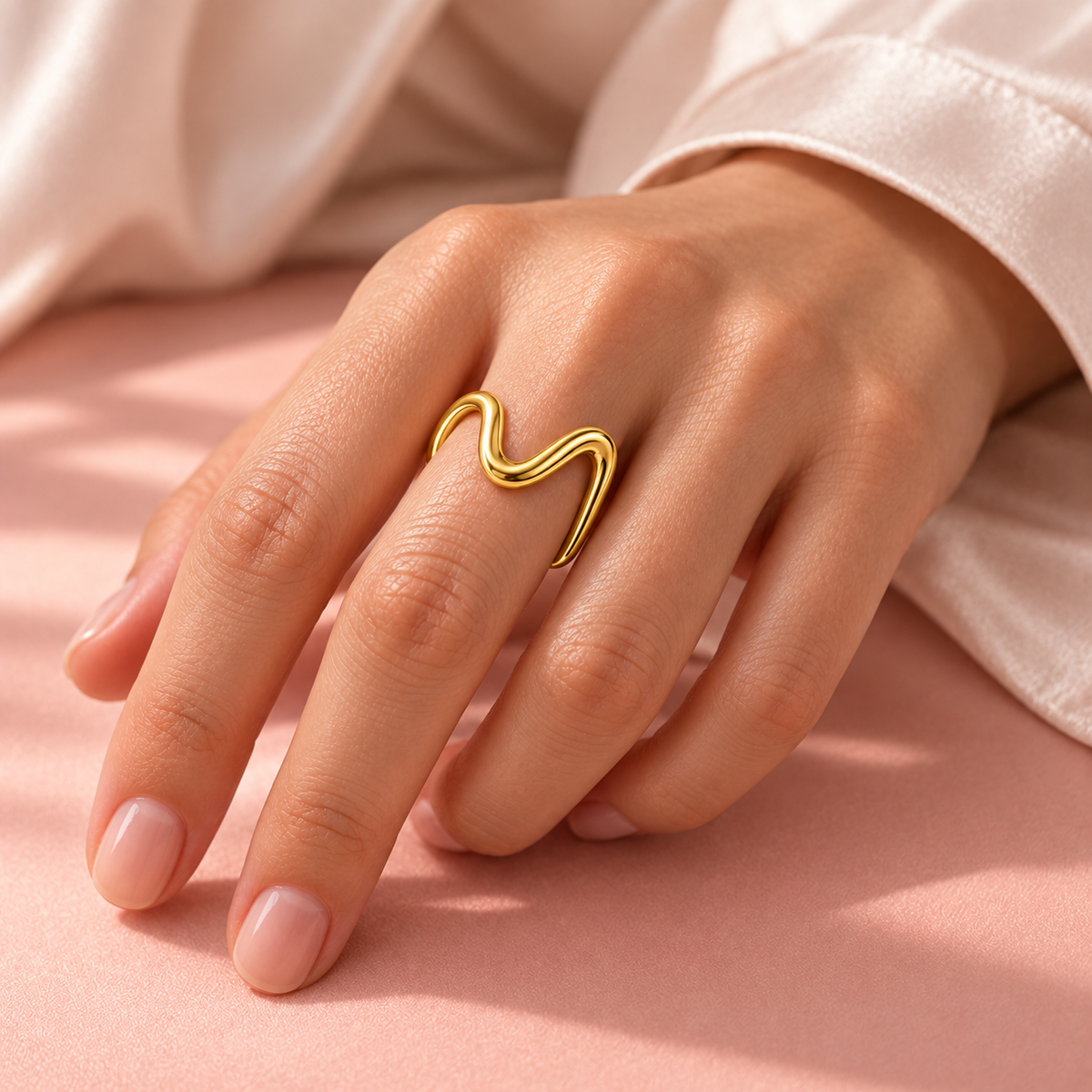 Gold-tone asymmetric wave ring, shown on a hand from another angle.