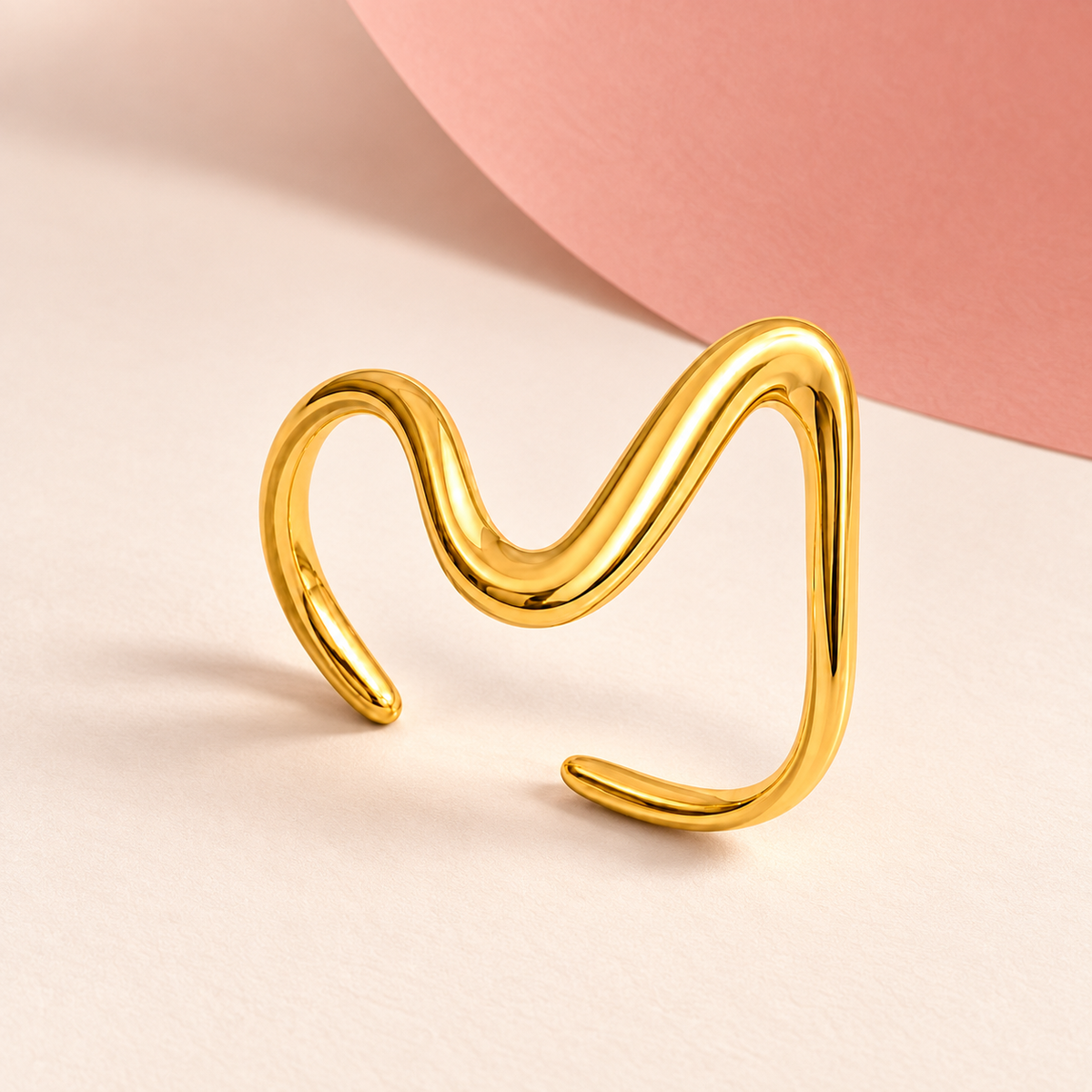Gold-tone asymmetric wave ring, styled product view.