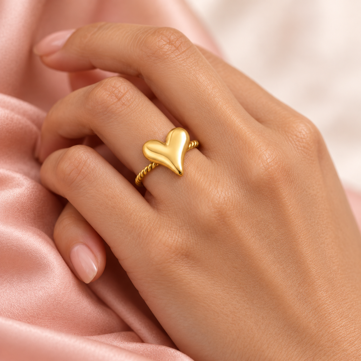 Gold-tone heart and rope ring, shown on a hand from another angle.