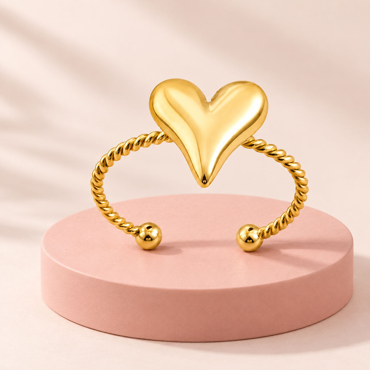 Gold-tone heart and rope ring, styled product view.