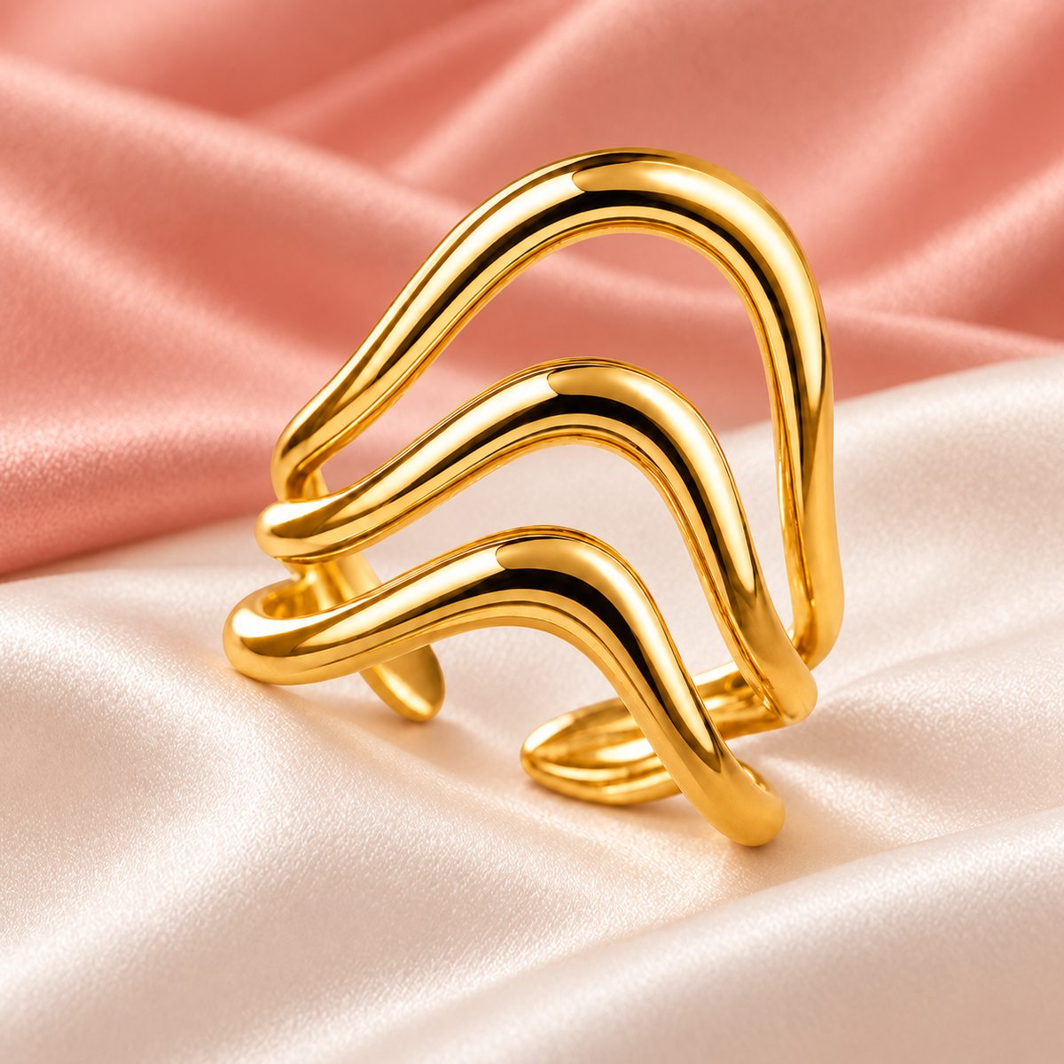 Gold-tone triple wave ring, still-life view on fabric.
