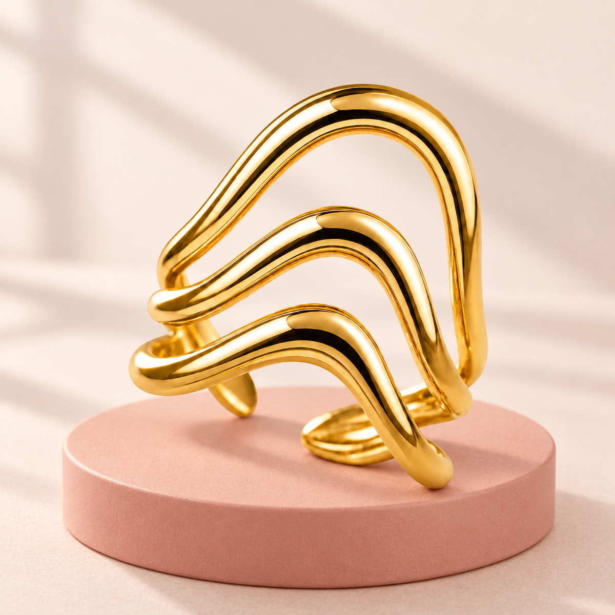 Gold-tone triple wave ring, styled product view.