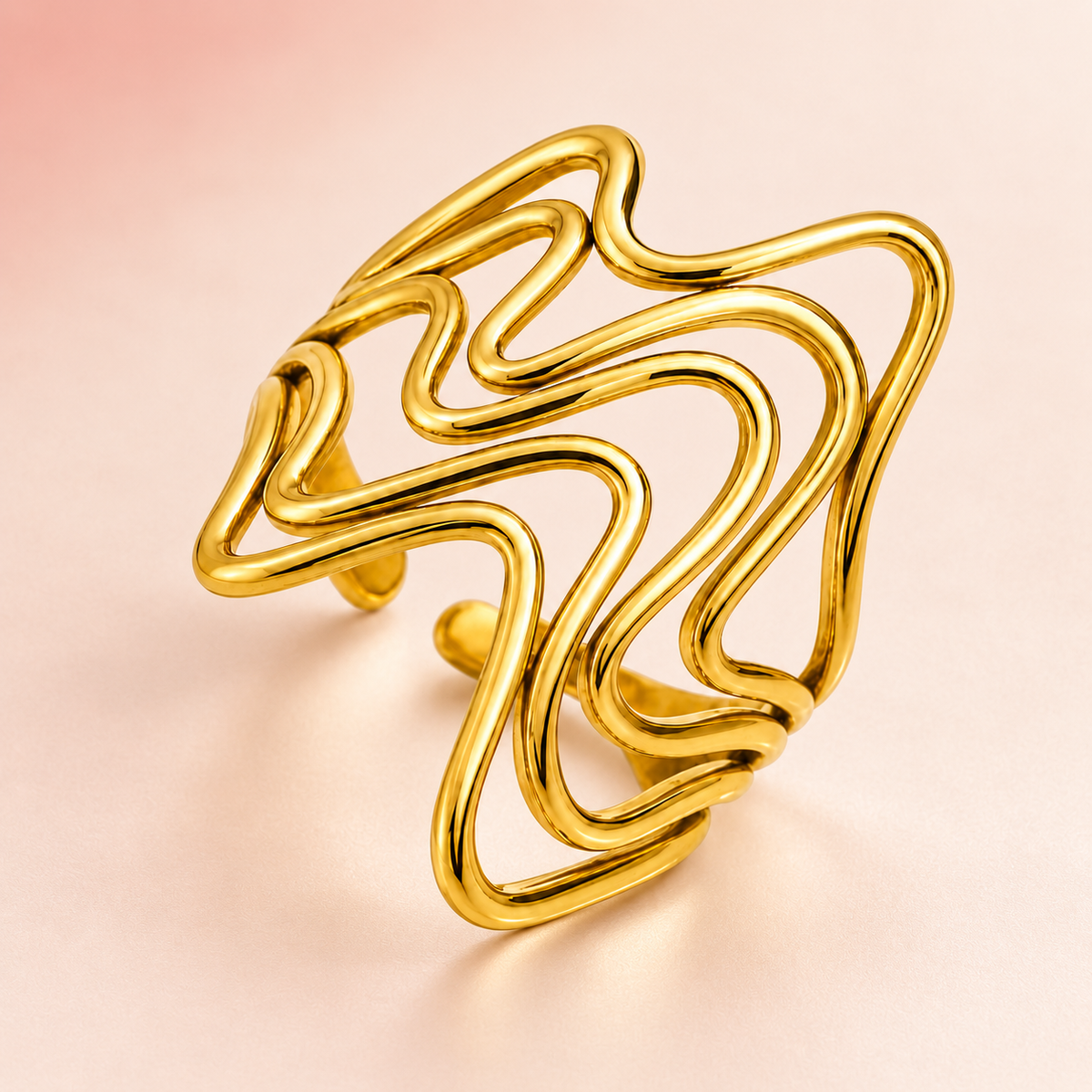 Gold-tone flowing wave ring, product view.