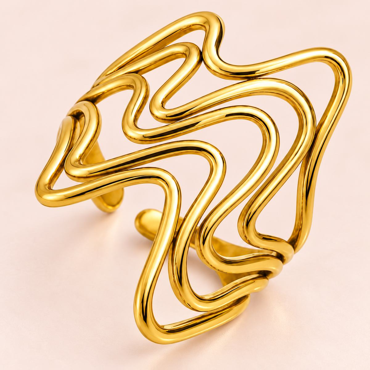 Gold-tone flowing wave ring, close-up view.
