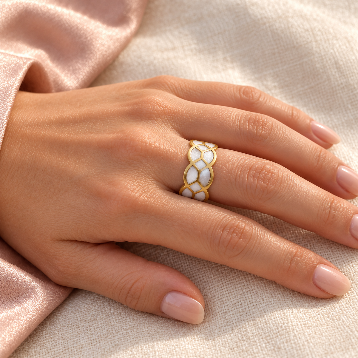 Gold-tone ring with white mosaic pattern, shown on a hand from another angle.