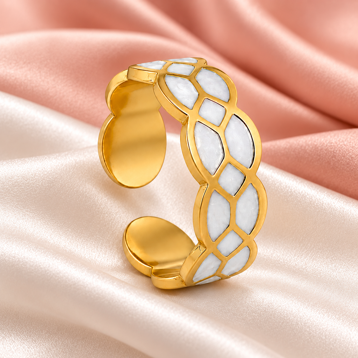 Gold-tone ring with white mosaic pattern, still-life view on fabric.