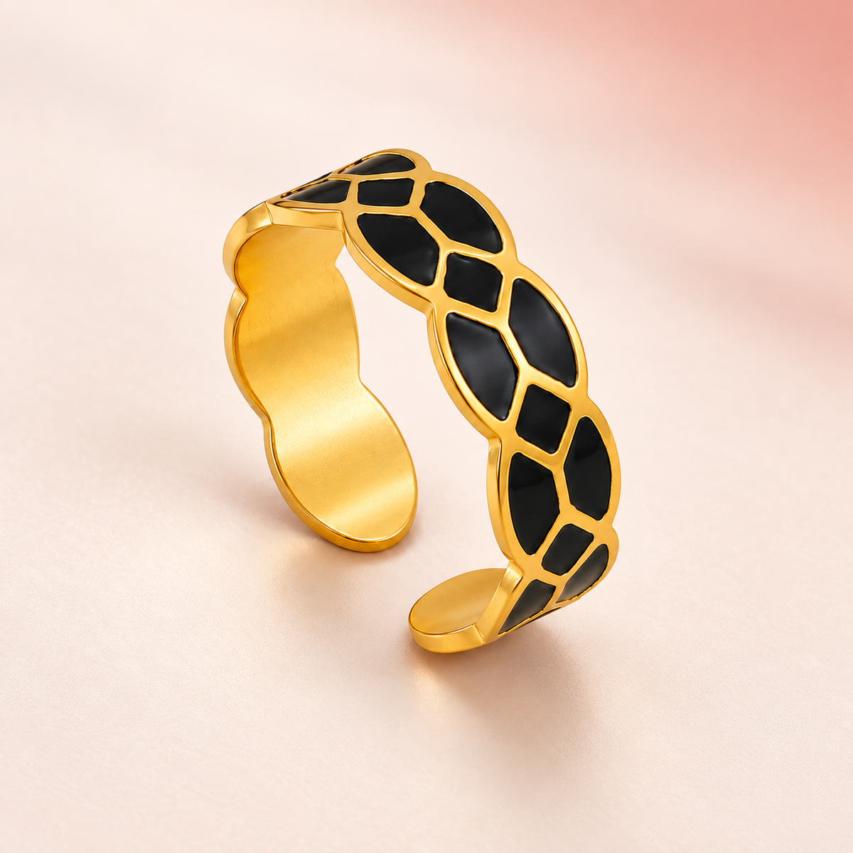 Gold-tone ring with black mosaic pattern, product view.