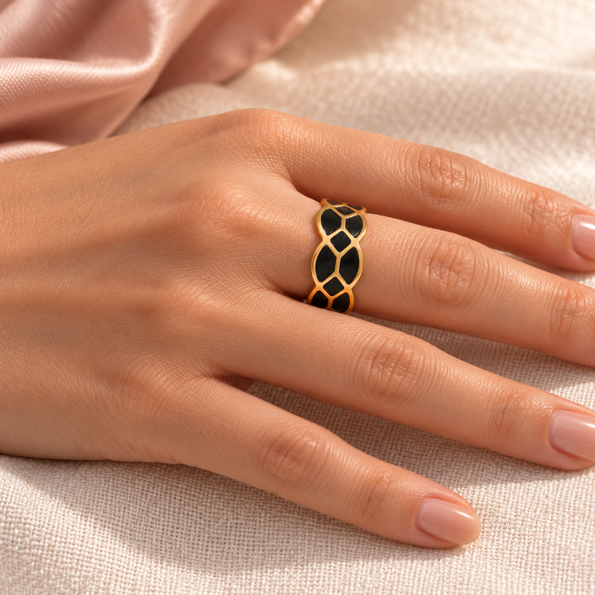 Gold-tone ring with black mosaic pattern, shown on a hand from another angle.