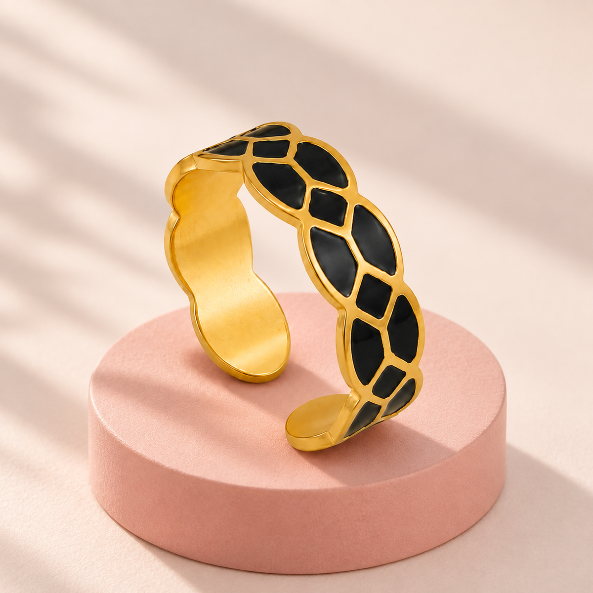 Gold-tone ring with black mosaic pattern, styled product view.