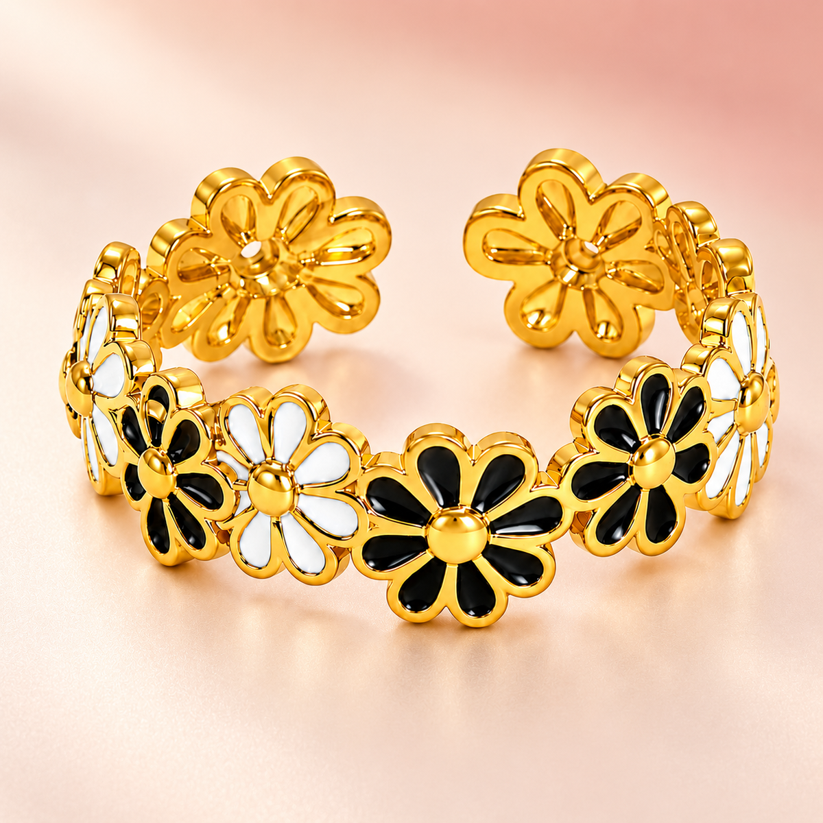 Gold-tone ring with black and white flowers, product view.