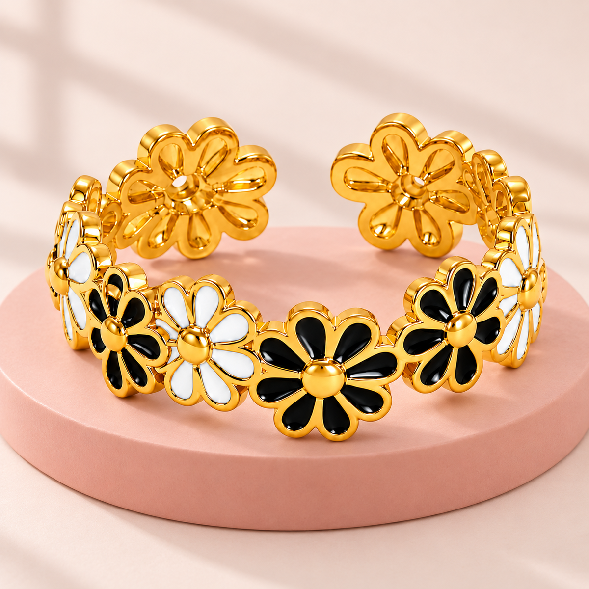 Gold-tone ring with black and white flowers, styled product view.