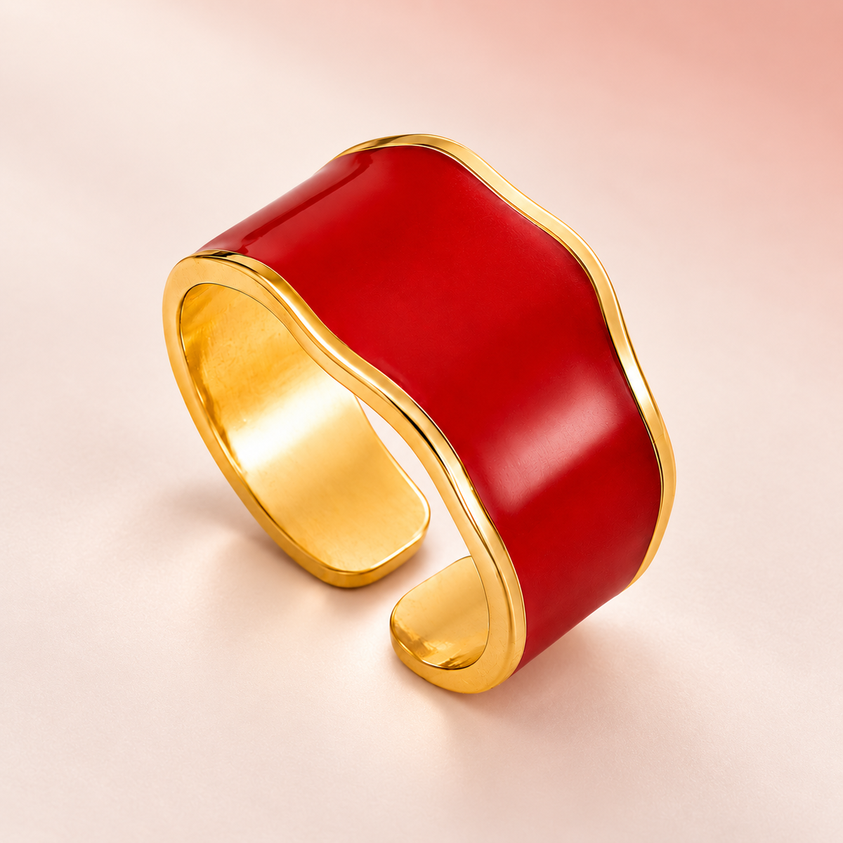 Red wave ring with gold-tone edges, product view.