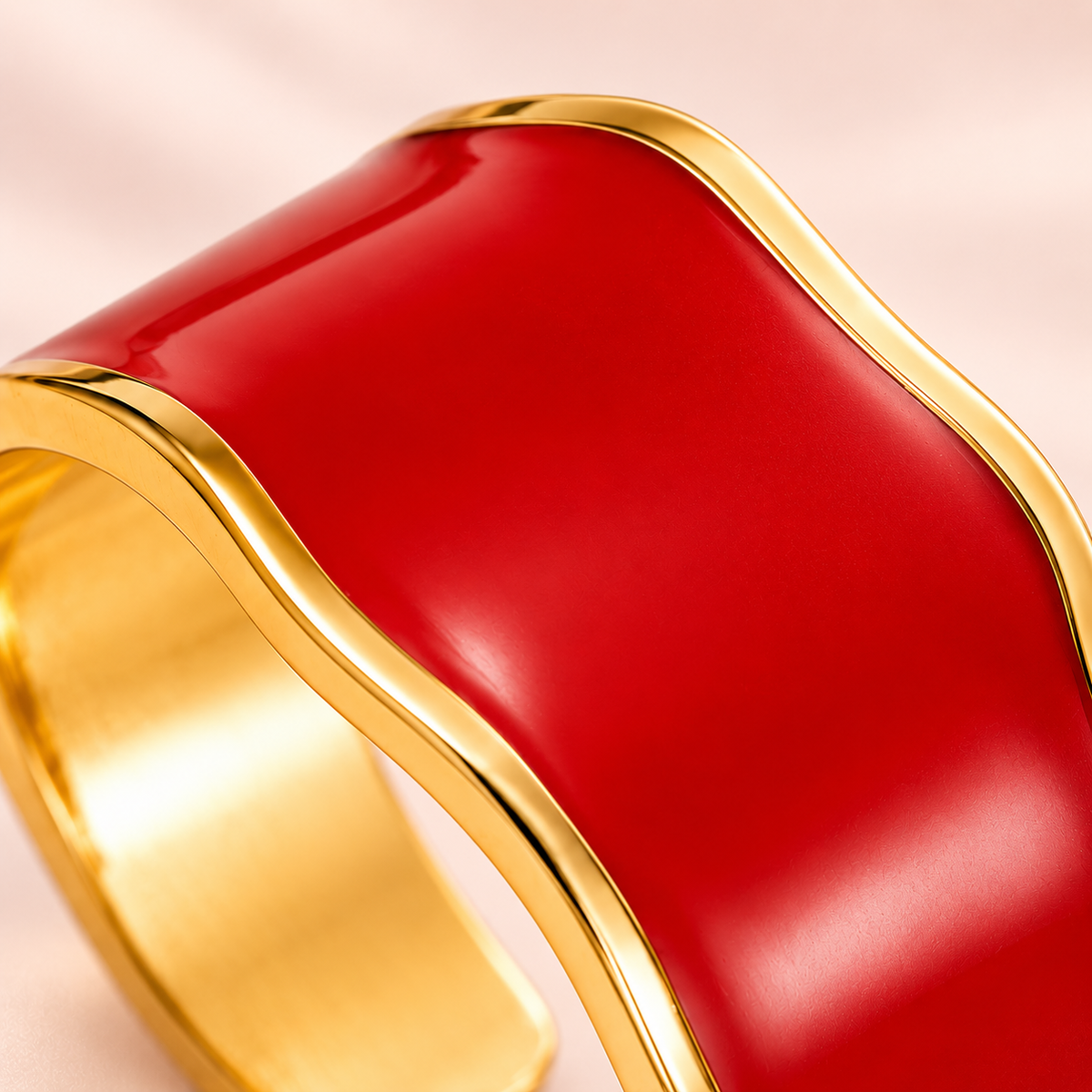 Red wave ring with gold-tone edges, close-up view.