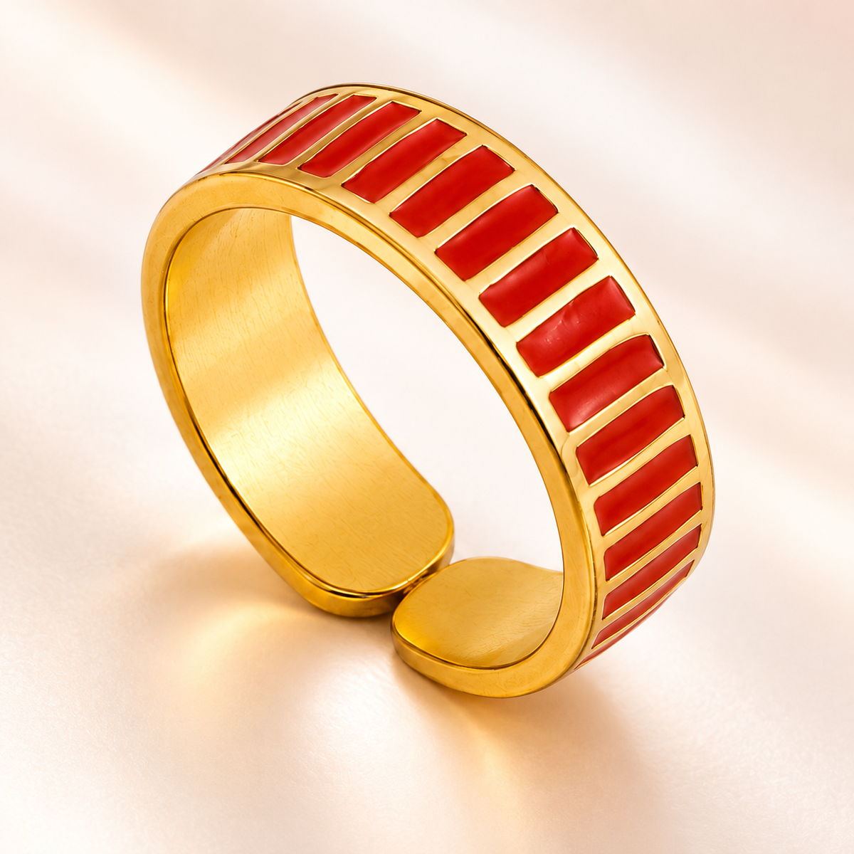 Gold-tone ring with red stripes, close-up view.