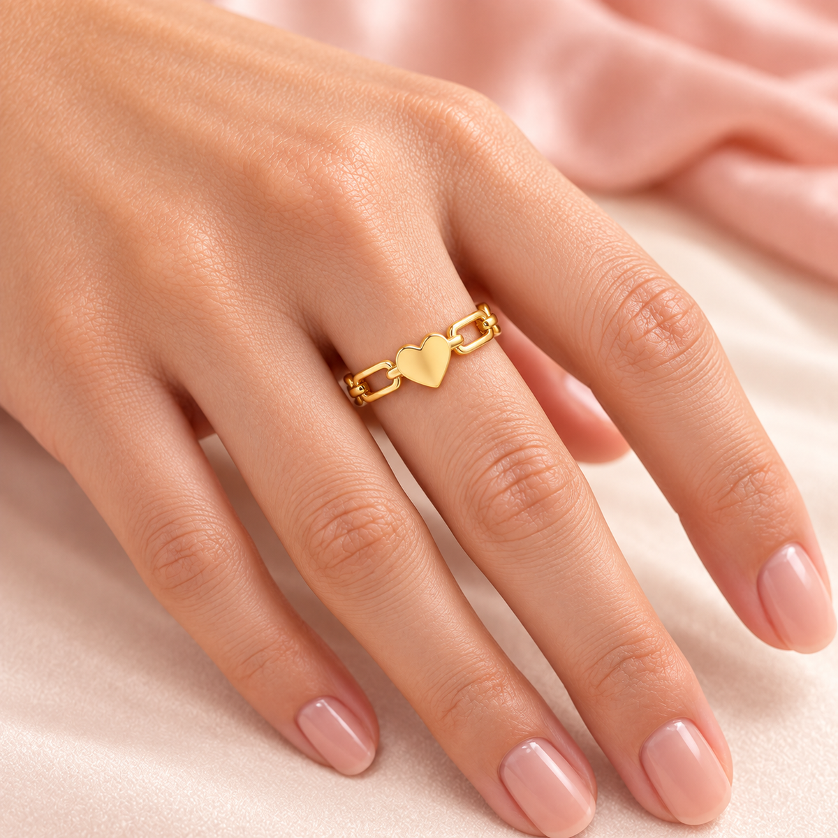 Gold-tone heart link ring, shown on a hand.