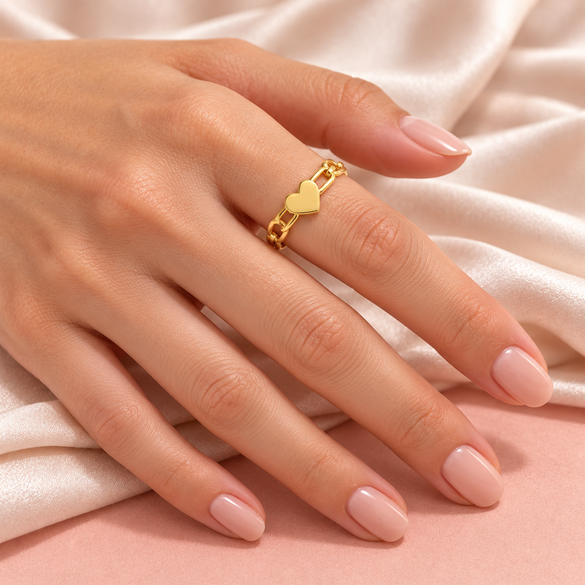 Gold-tone heart link ring, shown on a hand from another angle.