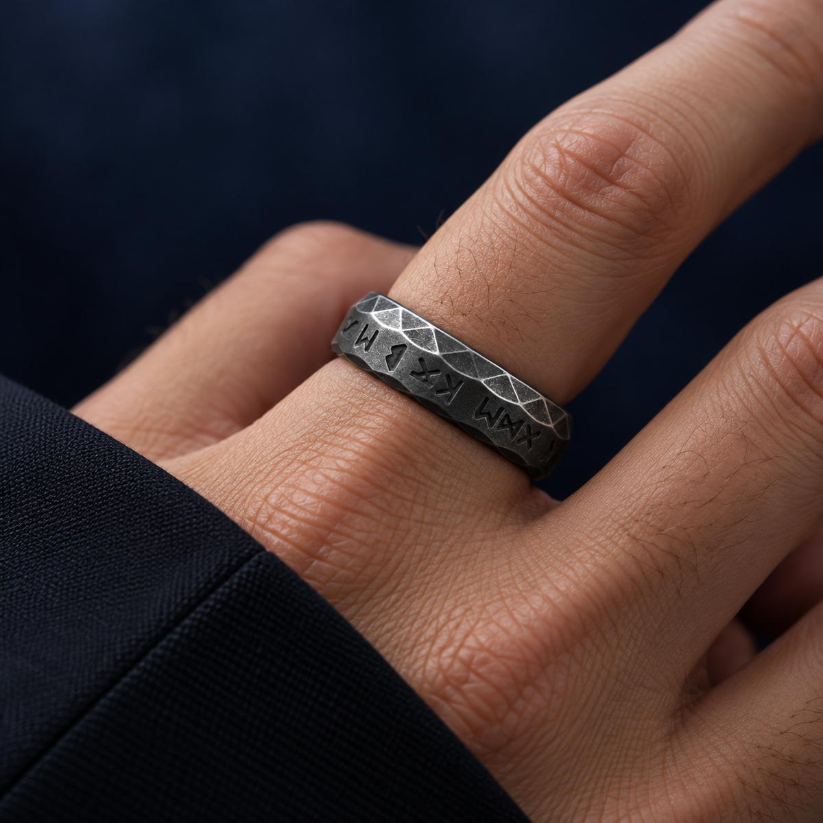 Dark-tone patterned band ring styled on a male hand