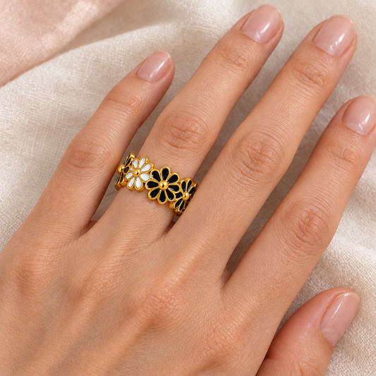 Black and white flower ring styled naturally on a hand