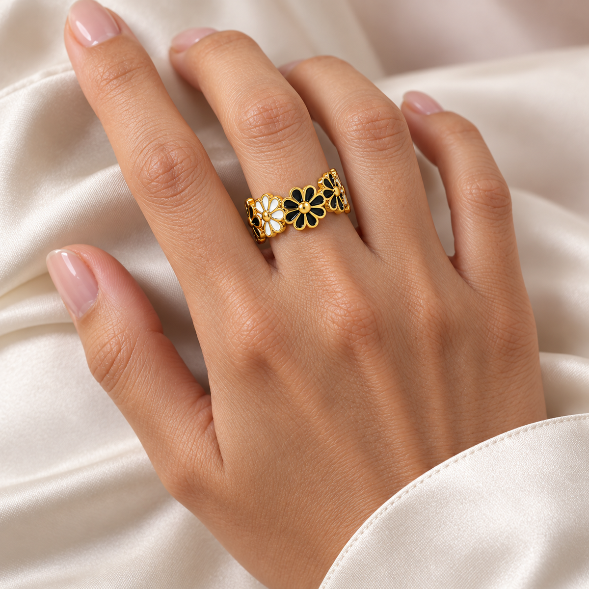 Black and white flower ring styled naturally on a hand